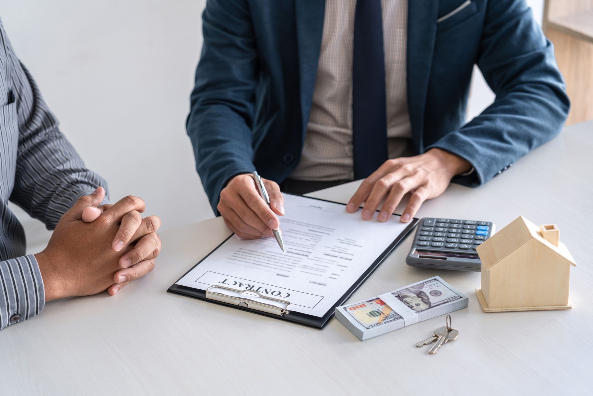 Agente de bienes raíces están presentando el préstamo de la casa y dando casa al cliente después de firmar el contrato para comprar la casa con el formulario de solicitud de propiedad aprobado