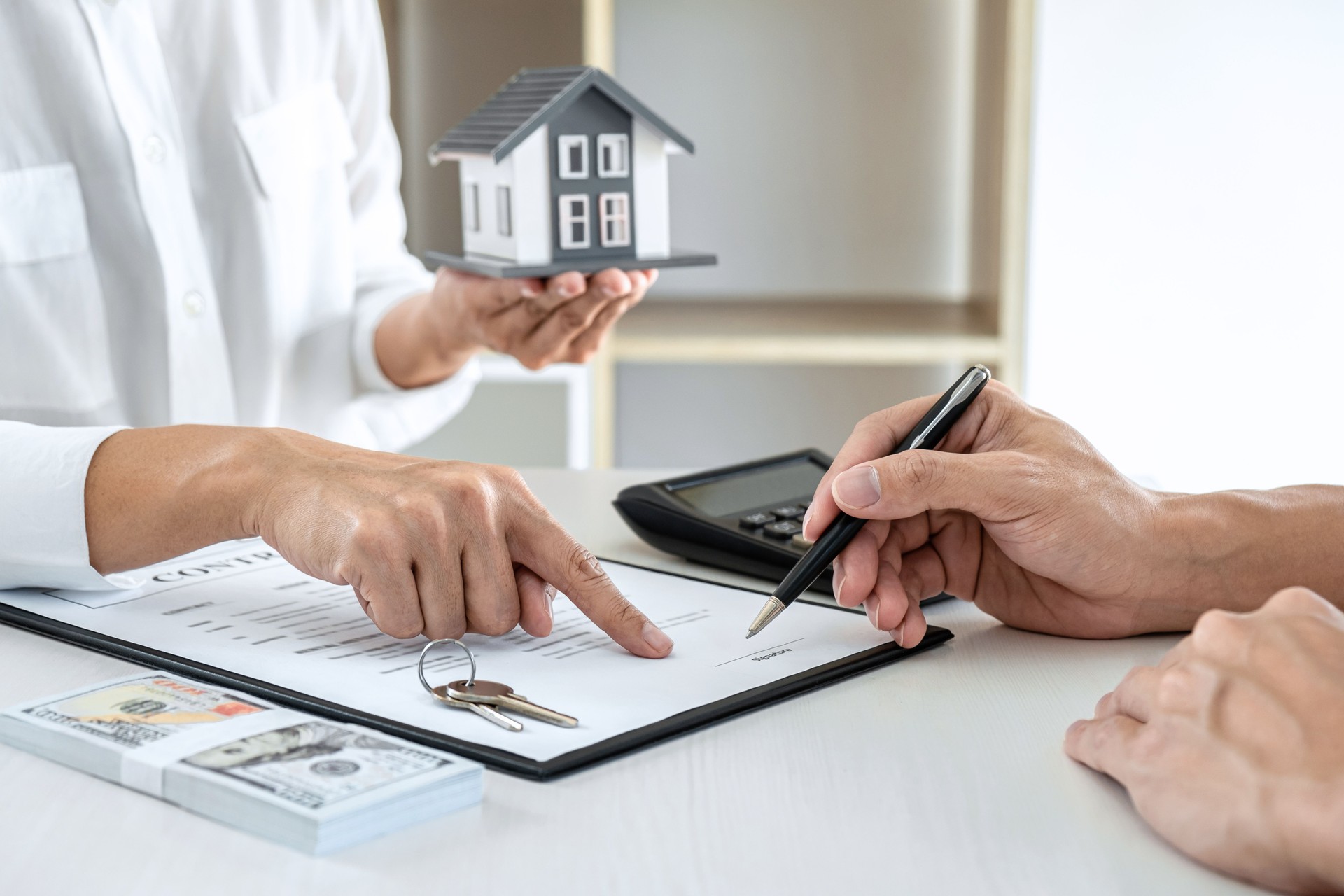 Agente de corretas de bienes raíces que presenta y consulta al cliente para la toma de decisiones firmar el acuerdo de formulario de seguro, modelo de vivienda, sobre la oferta de préstamo hipotecario y el seguro de la casa